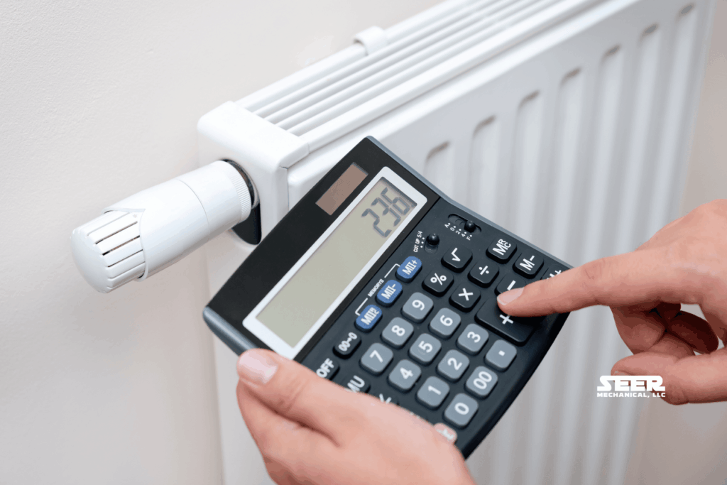 Person adjusting a radiator thermostat while calculating home heating costs, illustrating ways to lower heating expenses without sacrificing comfort.